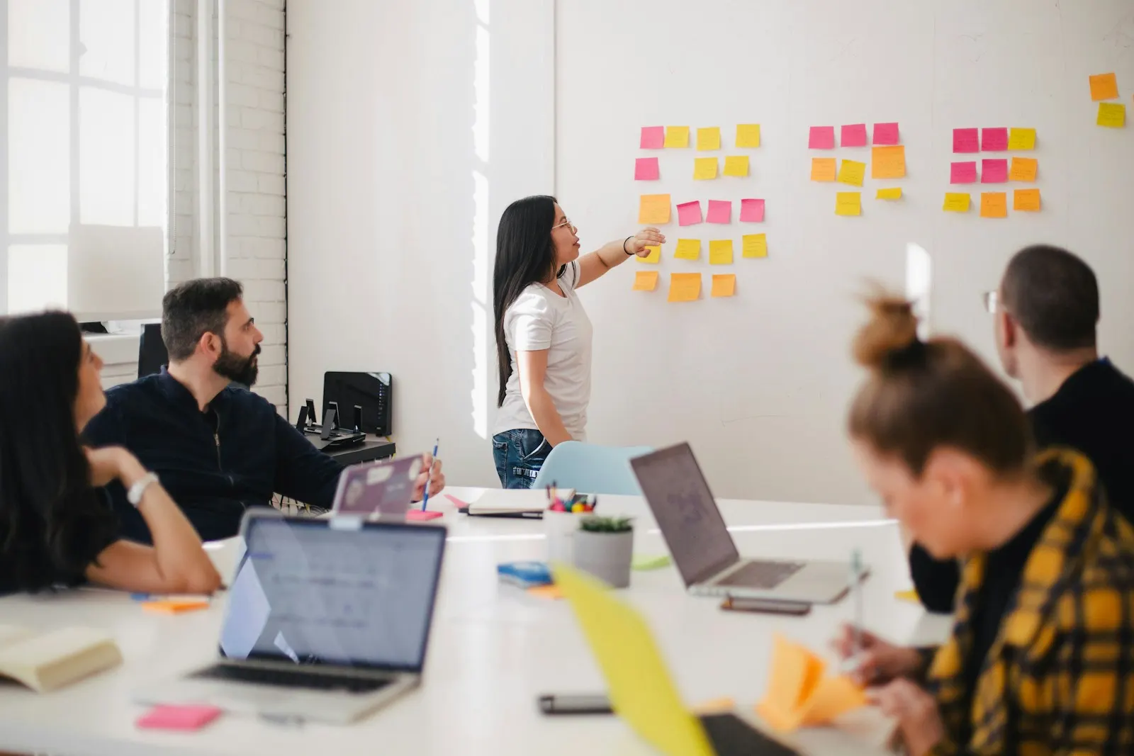 Atelier de travail : une équipe organise ses idées sur un mur de notes adhésives